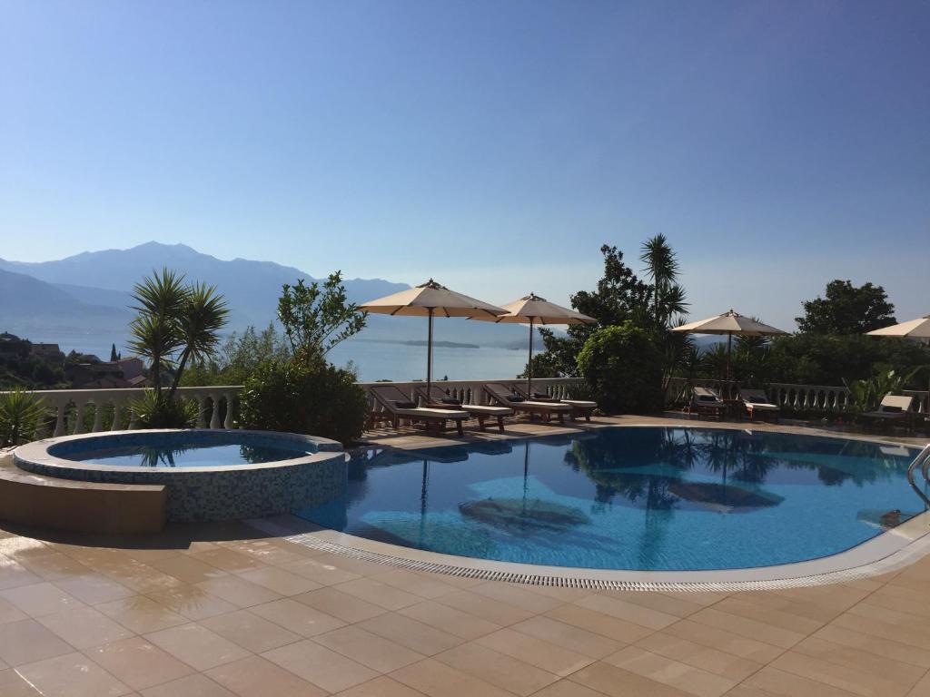 - une piscine avec des tables et des parasols dans l'établissement Monte Aria panorama suites, à Herceg-Novi