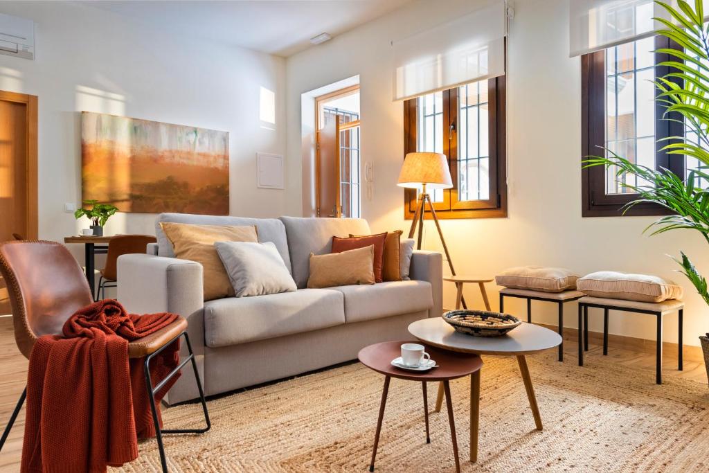 a living room with a couch and tables at MH Apartments Central Sevilla in Seville
