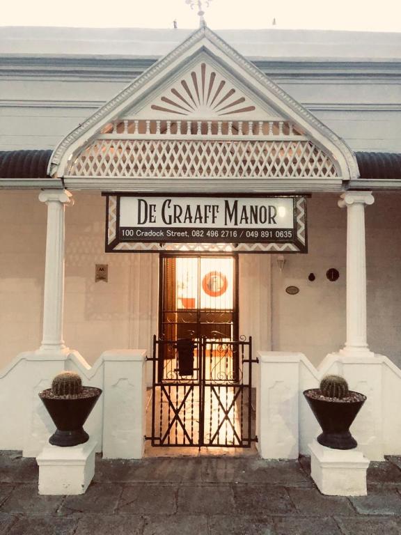 una porta d'ingresso di un edificio con un cartello sopra di De Graaff Manor a Graaff-Reinet