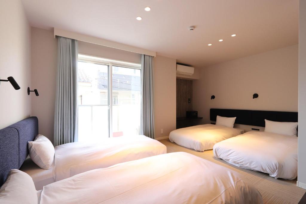 Duas camas num quarto com uma janela em 5 minutes Shin-Osaka 9 em Osaka