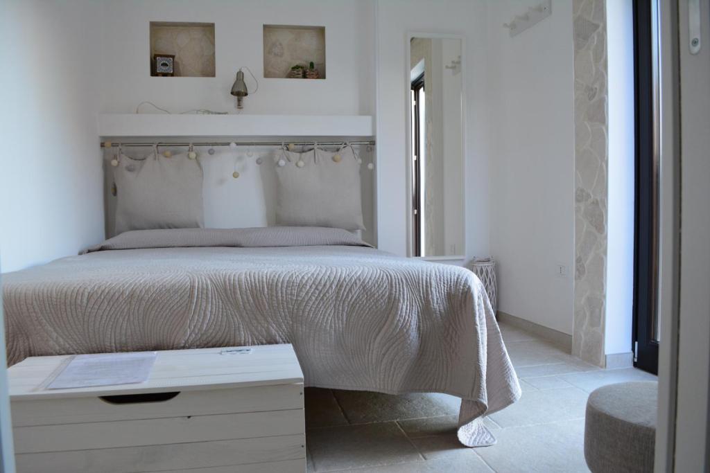 a white bedroom with a large bed with a white blanket at Flavì in Bari