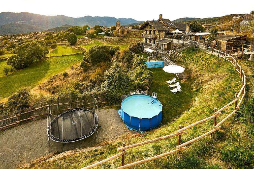Buerba的住宿－CASA Guardafuentes de Ordesa，享有山丘上带热水浴池的房屋的空中景致