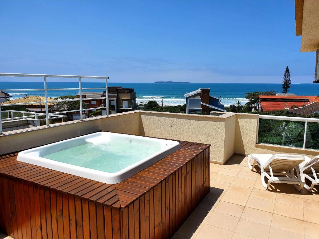 a hot tub sitting on top of a balcony at Cobertura Jacuzzi Vista Mar in Bombinhas