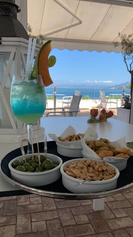 a table with plates of food and a drink at Relais Maresca Luxury Small Hotel & Terrace Restaurant in Capri