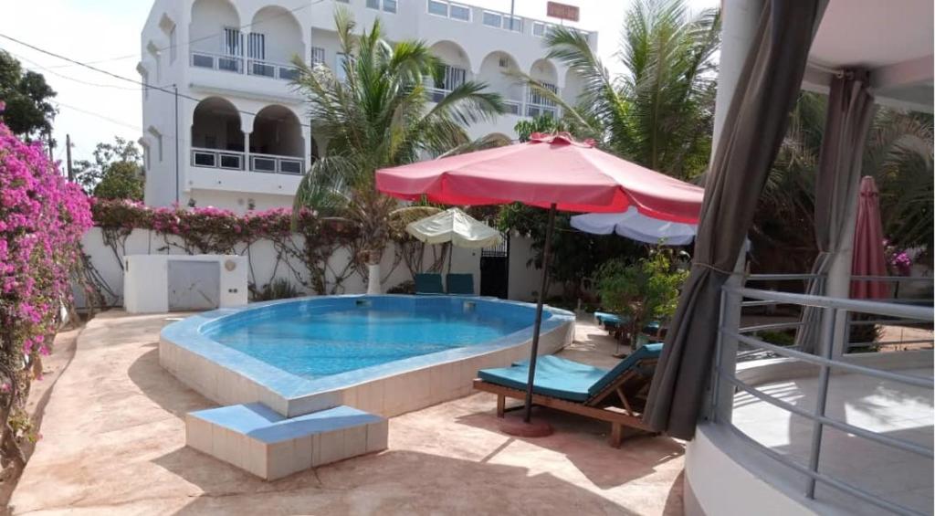 a swimming pool with an umbrella and a chair at Residence Saint James in Somone