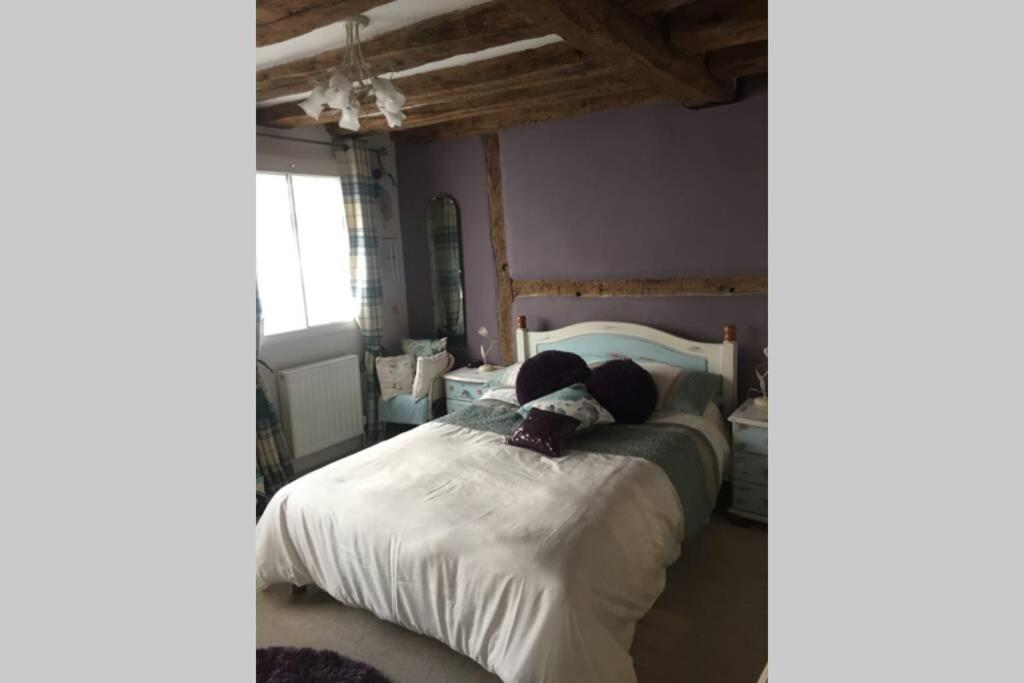 um quarto com uma cama com lençóis brancos em Potters Court A Hidden Gem em Tewkesbury