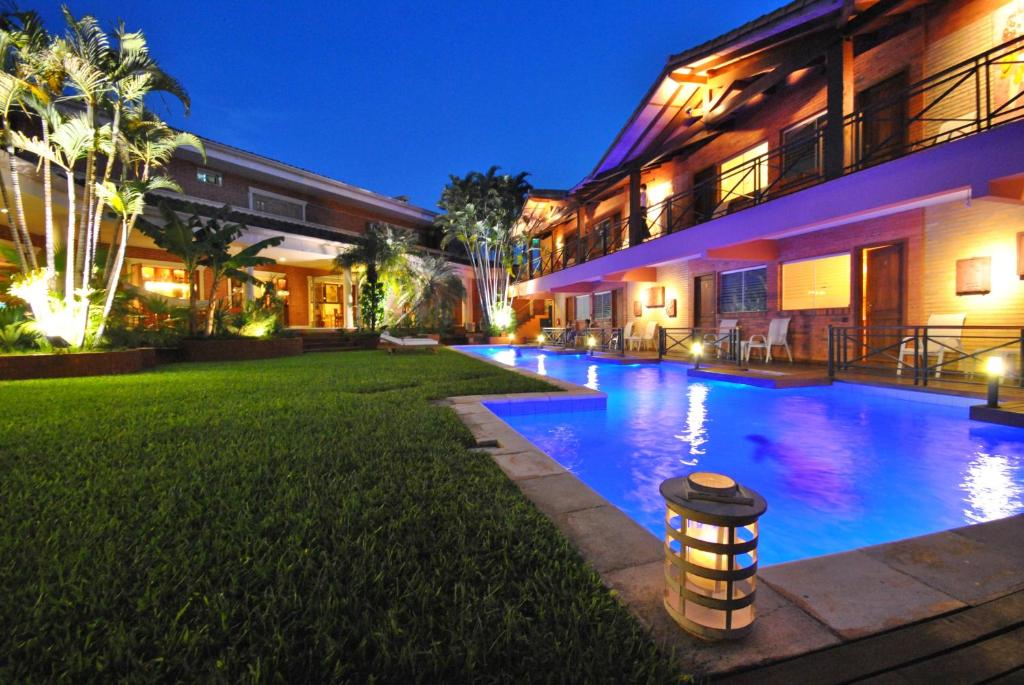 a swimming pool in front of a building at night at Villa Floreal Hotel Boutique in Asunción
