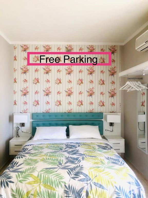 a bedroom with a bed with a free parking sign above it at Lovely Apartments D in Patra