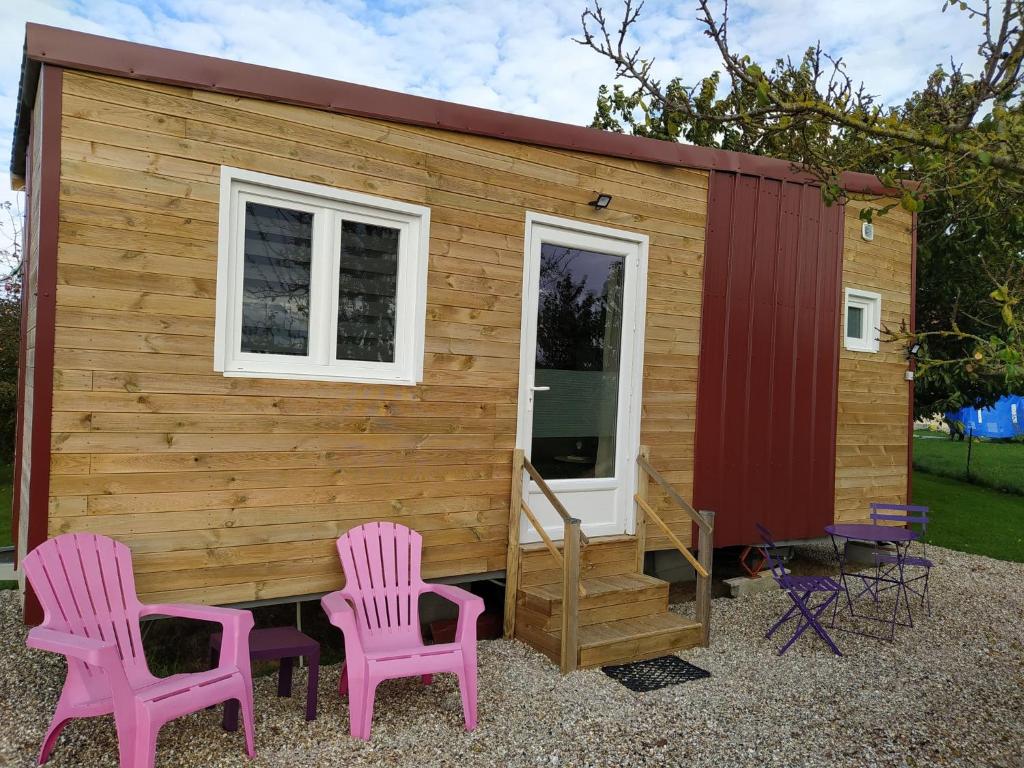 a tiny house with two pink chairs in front of it at Tiny house in Amécourt