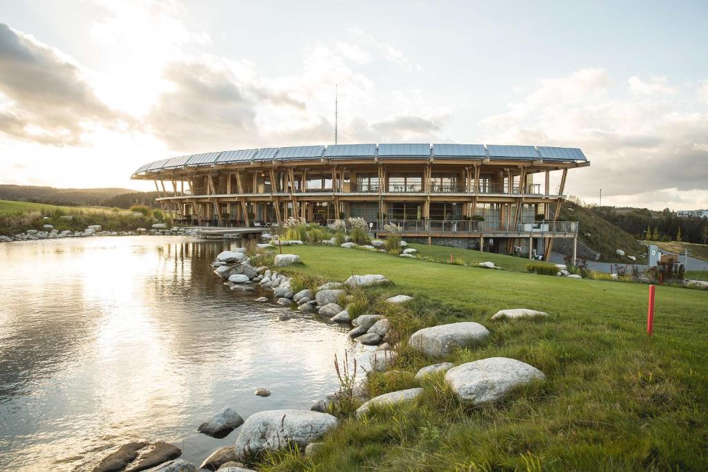 a large building next to a body of water at Panorama Golf Resort in Kácov