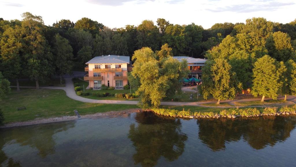 an aerial view of a house next to a lake at Badehaus Hotel & Restaurant in Neubrandenburg