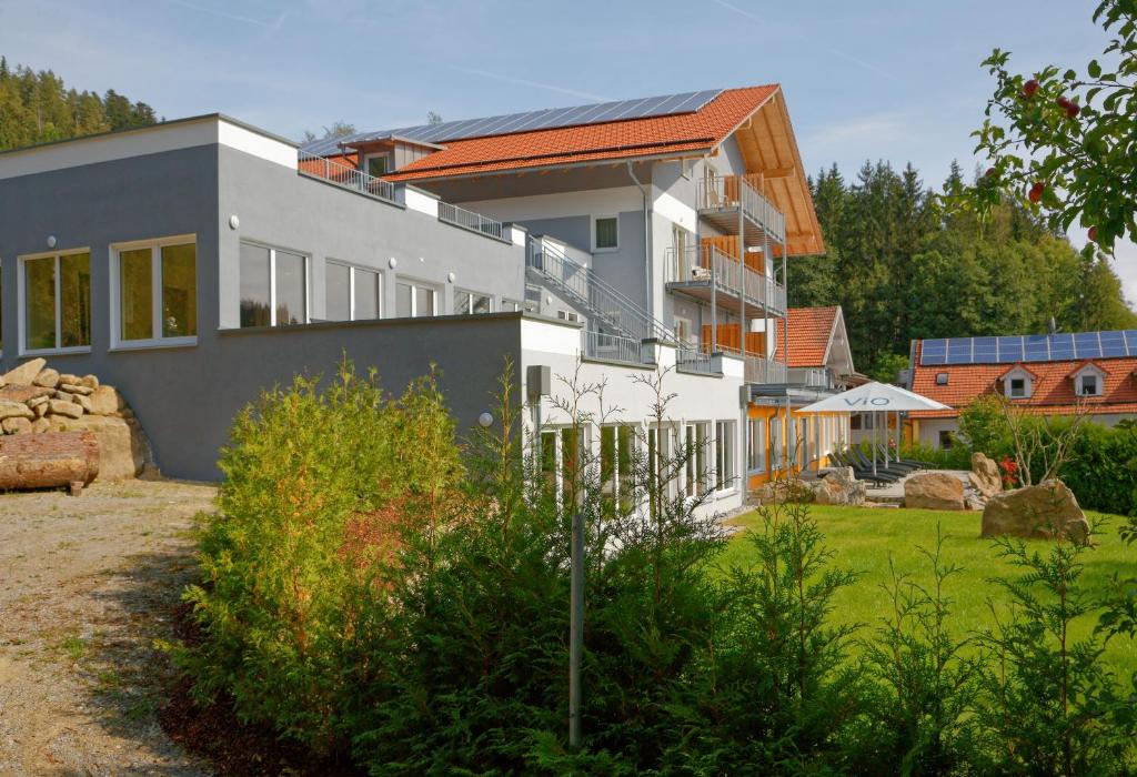 une maison avec beaucoup de fenêtres dans une cour dans l'établissement Wellnesshotel deine Auszeit, Adults only, à Achslach