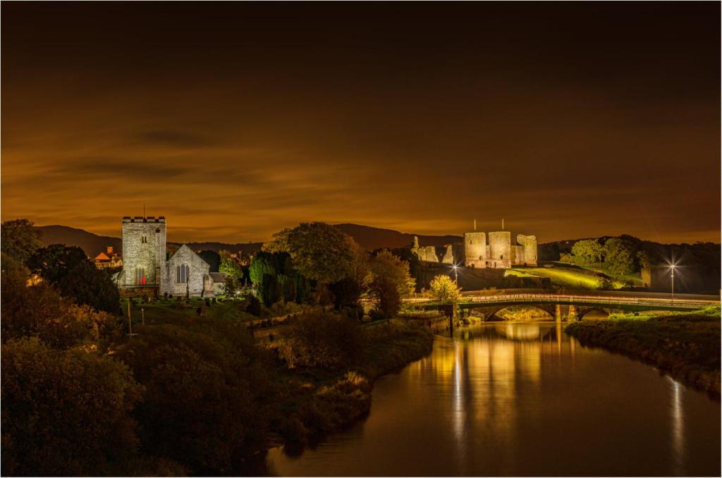 a castle and a bridge over a river at night at Garden Suite in Rhuddlan