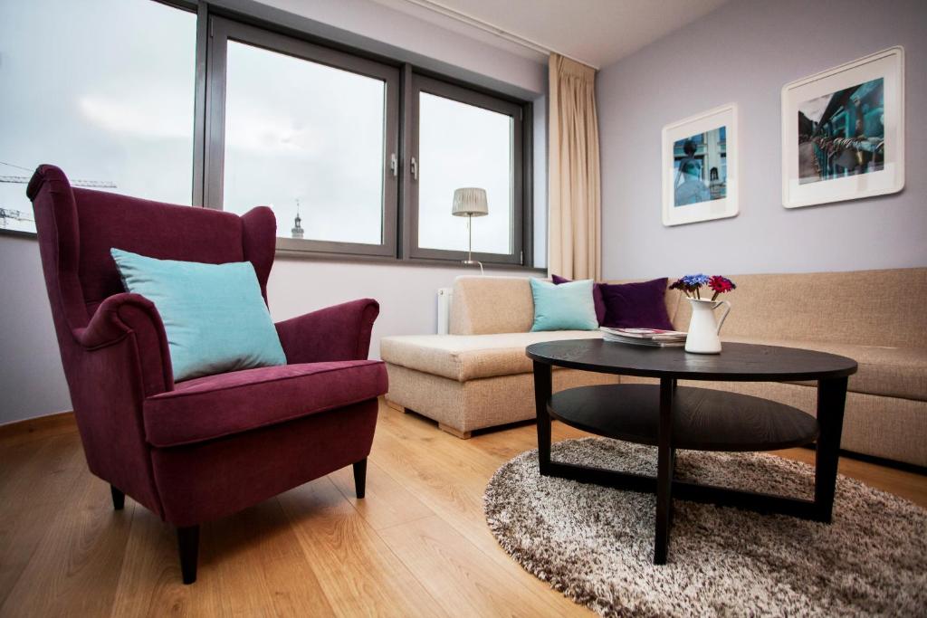 a living room with a chair and a table at Silver Apartments in Wrocław