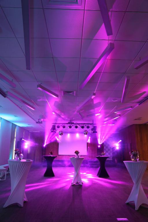 uma sala com luzes roxas e mesas em Hotel Cabaña Del Lago Puerto Varas em Puerto Varas