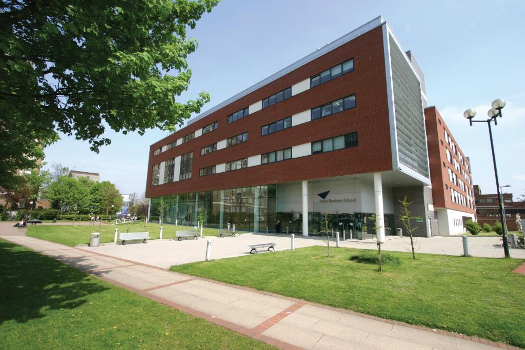 a large brick building with benches in front of it at Conference Aston Hotel - Birmingham City in Birmingham