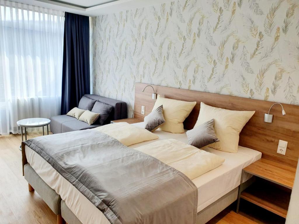 ein Schlafzimmer mit einem großen Bett und einem Stuhl in der Unterkunft Haus am See Luxury HS 948 in Hahnenklee-Bockswiese