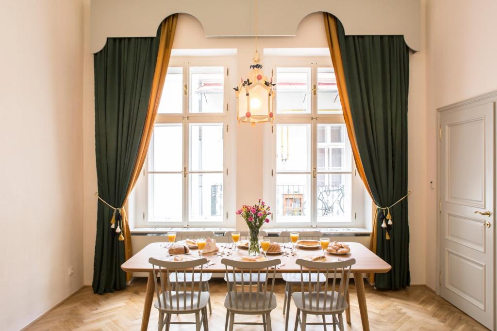 a dining room with a table and chairs and a window at Downtown Designer apartment Karlin in Prague