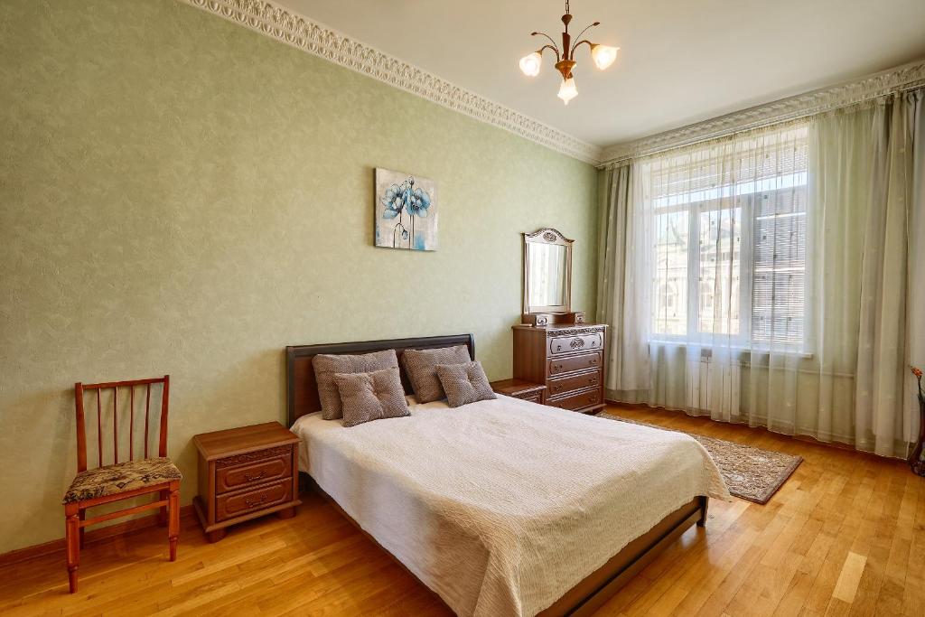 - une chambre avec un lit, une chaise et une fenêtre dans l'établissement Apartment near Lva Tolstoho Square, à Kiev