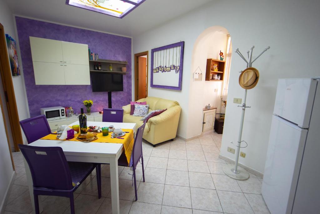een keuken en een woonkamer met een tafel en stoelen bij My House Holiday Apartment in Palermo