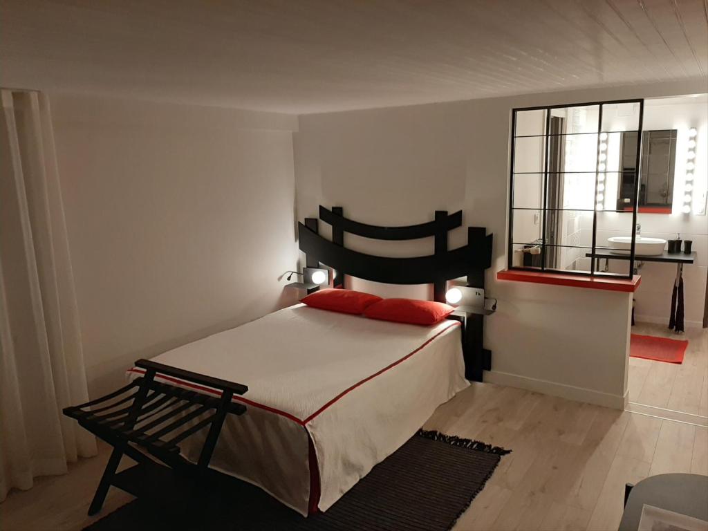Schlafzimmer mit einem Bett mit einem schwarzen Kopfteil und einem Fenster in der Unterkunft SAKURA in Fontaine-le-Comte