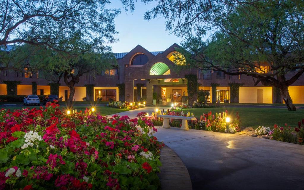 a building with a garden with flowers and a bench at The Lodge at Ventana Canyon in Tucson