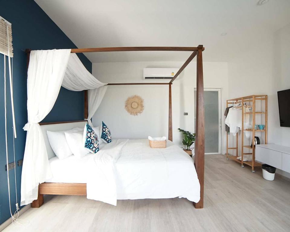 a bedroom with a canopy bed with white sheets at Wayla Villa@Maikhaobeach in Mai Khao Beach
