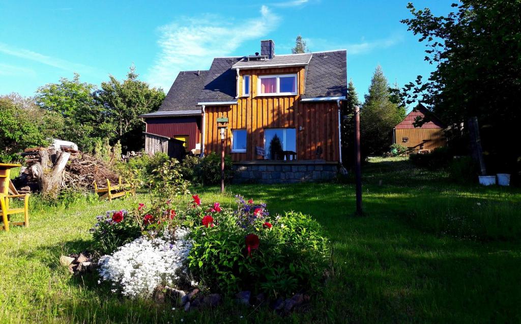 a house with a garden with flowers in the yard at Ferienhaus Fernblick Altenberg in Kurort Altenberg