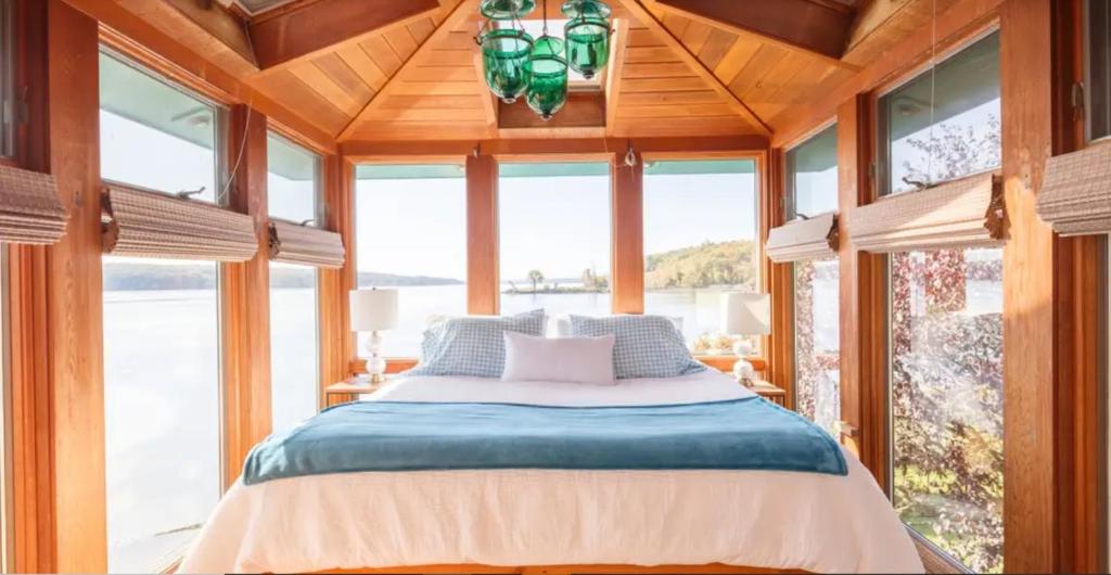 - une chambre avec un lit dans une pièce dotée de fenêtres dans l'établissement Hudson Riverfront Home, à Catskill