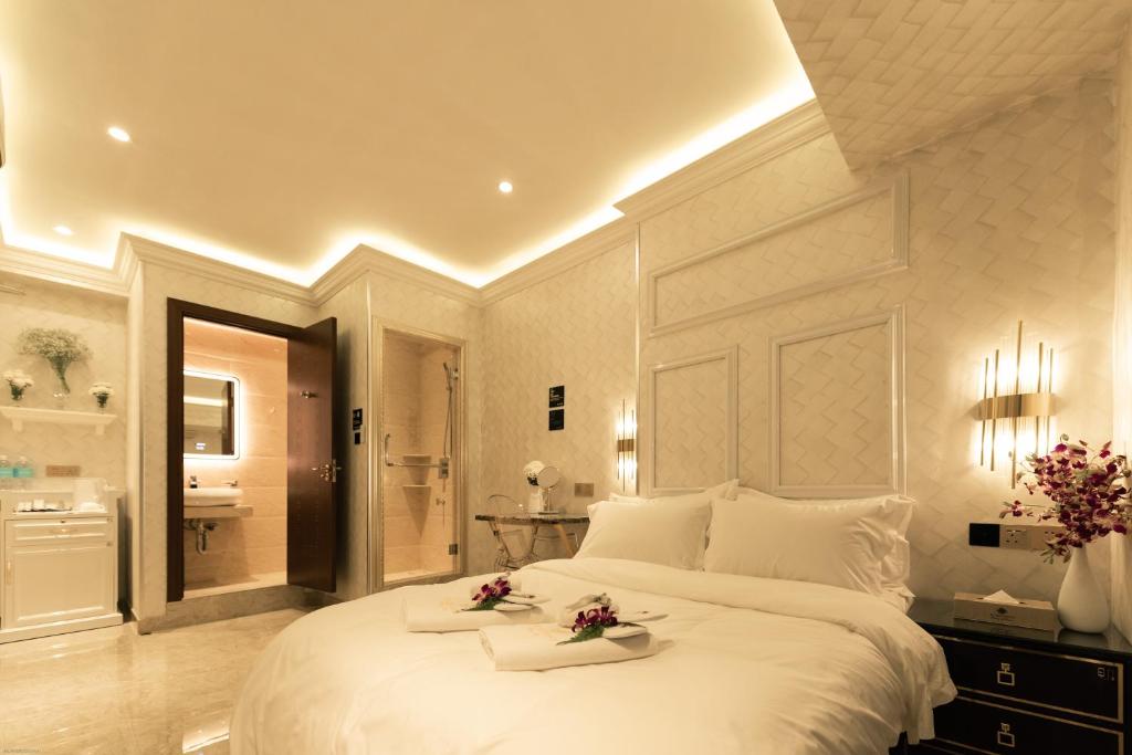 um quarto com uma grande cama branca e uma casa de banho em AJ Residence - Above Peppermint Asia City em Kota Kinabalu