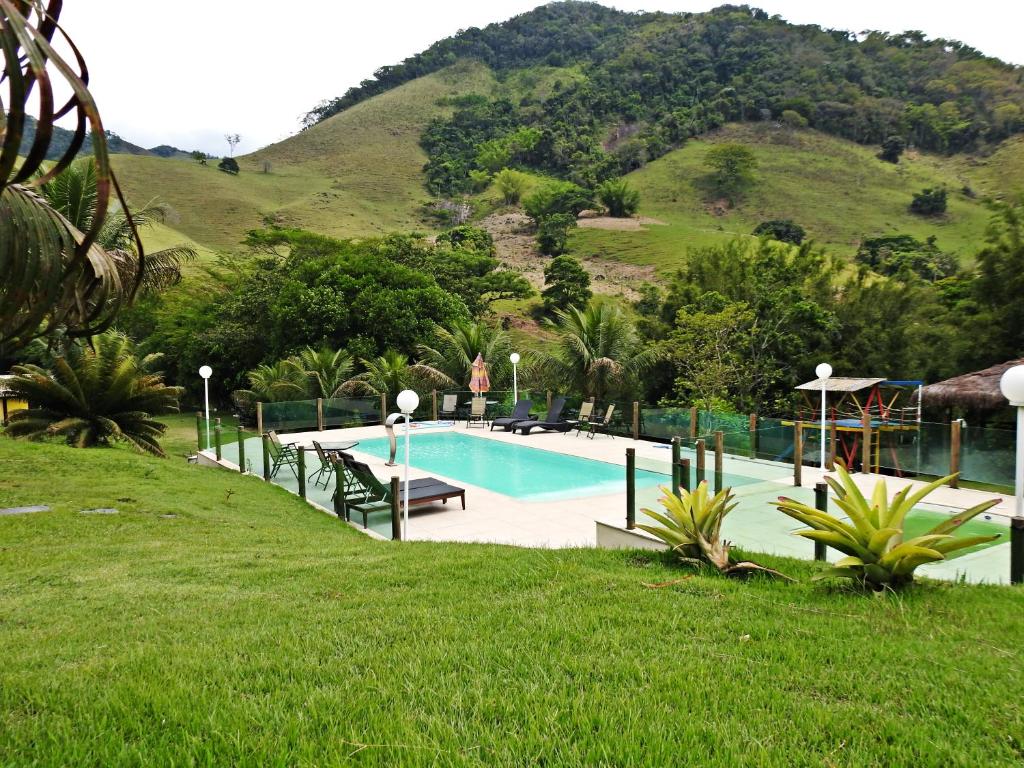 a swimming pool with a mountain in the background at Hotel Pousada Bambuzal in Sana