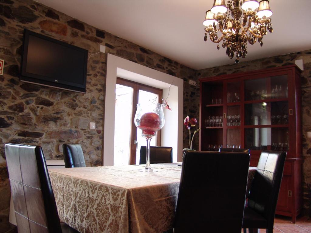 uma sala de jantar com uma mesa com cadeiras e um lustre em Casa Santa Catarina em Penha Garcia