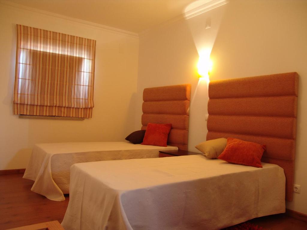 - une chambre avec 2 lits et une lumière sur le mur dans l'établissement Casa Santa Catarina, à Penha Garcia