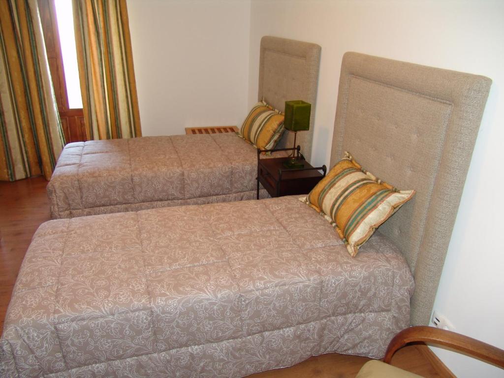 um quarto com 2 camas e uma mesa de cabeceira com um candeeiro em Casa Santa Catarina em Penha Garcia