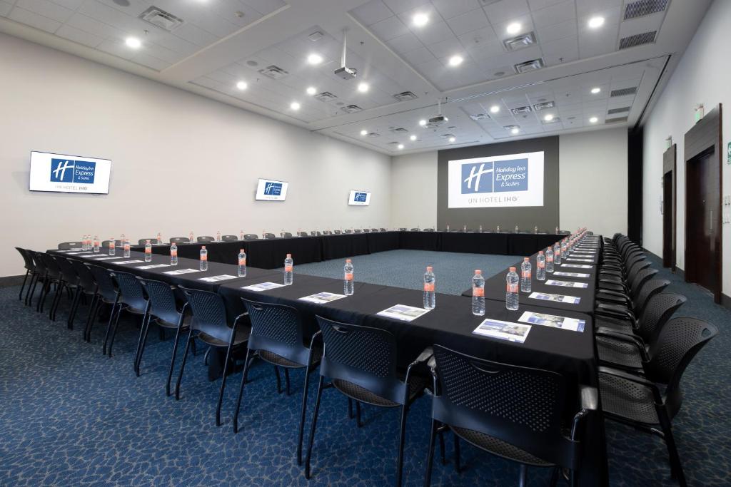 a long table in a room with chairs and a screen at Holiday Inn Express Hotel & Suites Hermosillo by IHG in Hermosillo