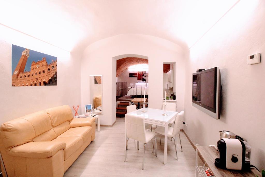 uma sala de estar com um sofá e uma mesa em Suite al Duomo em Siena