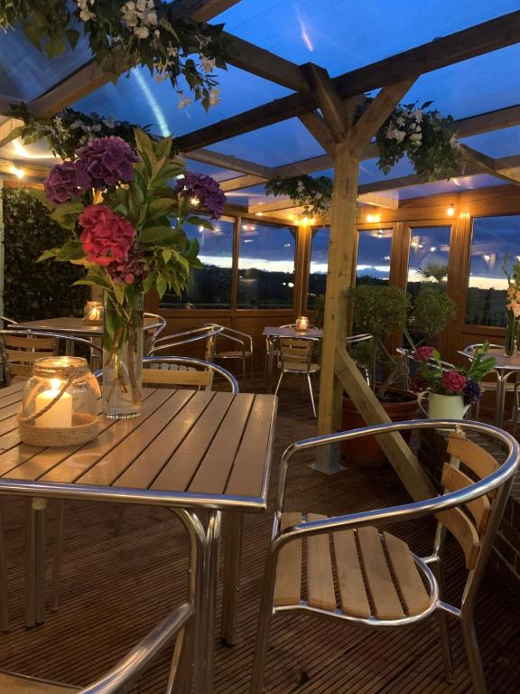 un tavolo in legno con un vaso di fiori su un ponte di Beamish Park Hotel a Beamish