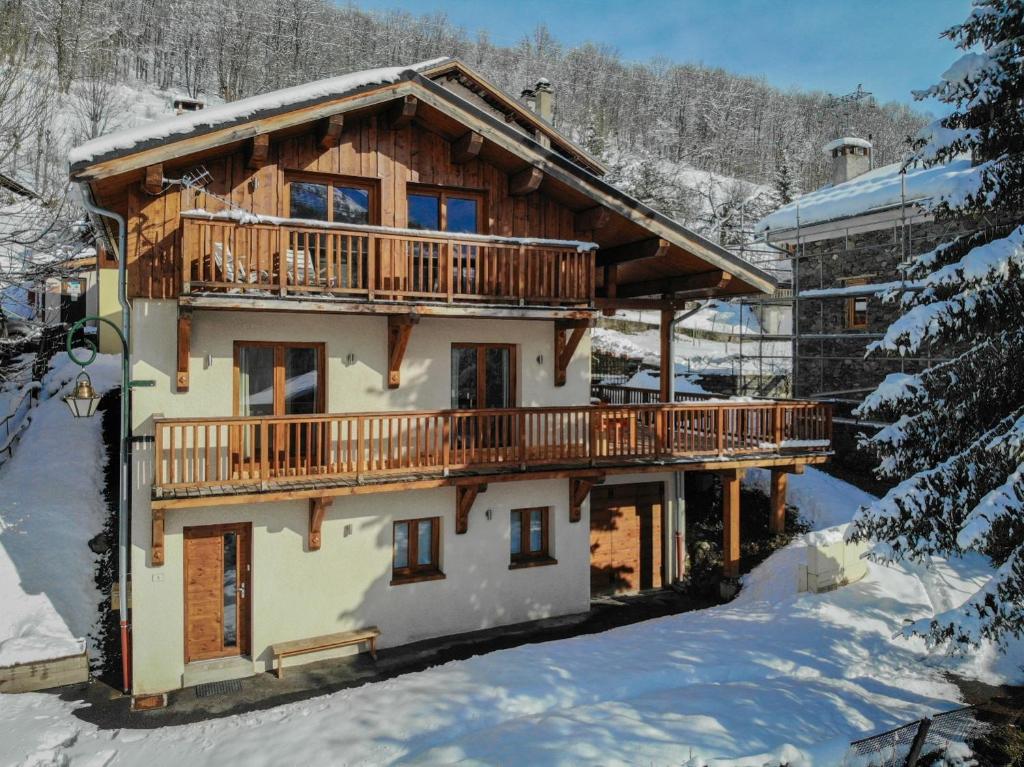 une maison en rondins avec une terrasse dans la neige dans l'établissement Chalet soFlo -5 FLOCONS OR - 3 Vallées - Saint-Martin-de-Belleville-9personnes-130m2, à Saint-Martin-de-Belleville