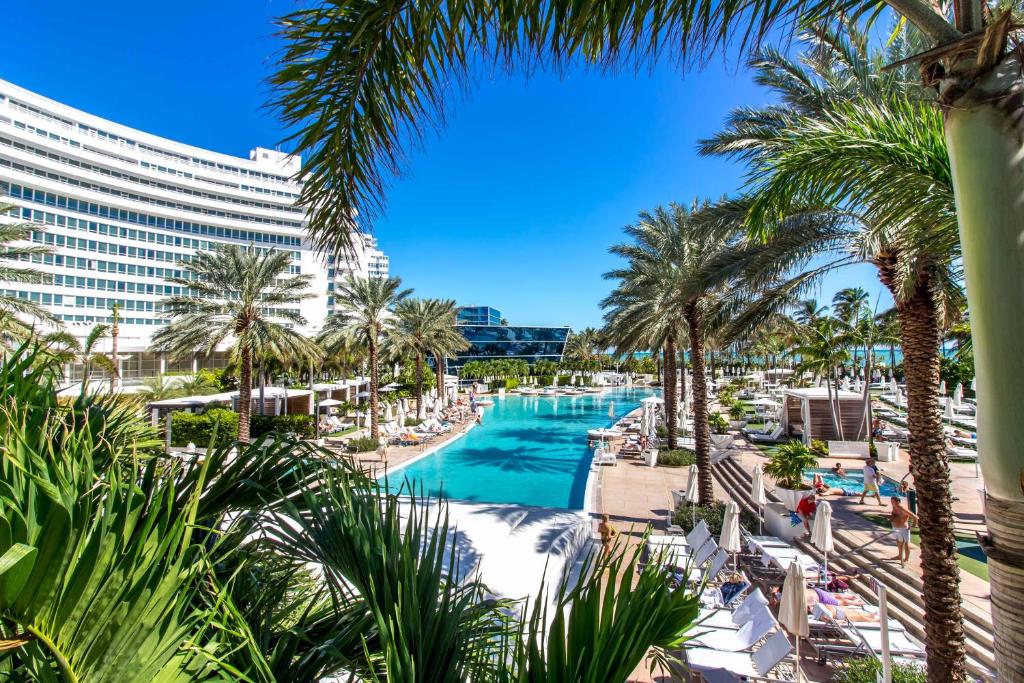 a view of the pool at the resort with palm trees at FB Miami Beach Tresor Private Luxury Suites in Miami Beach