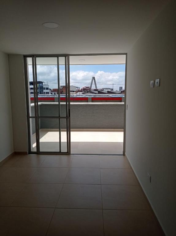 een lege kamer met een grote glazen deur met uitzicht bij Apartamento cerca a Pereira in Dosquebradas