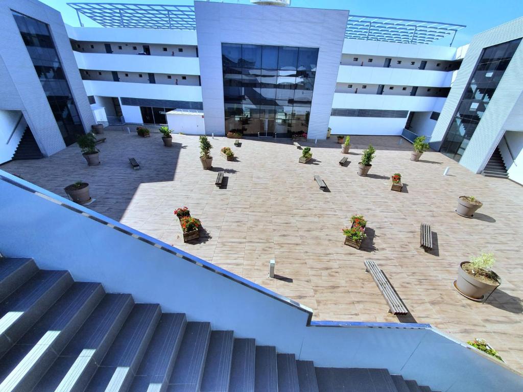 un grand bâtiment avec des escaliers et des plantes dans une cour dans l'établissement Iberflat Vega de Triana, à Camas