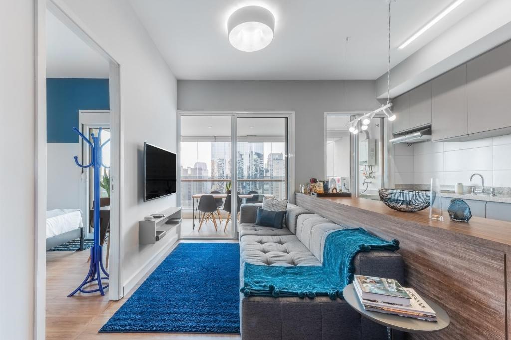 a living room with a couch and a blue rug at Charlie One Eleven Vila Olímpia in Sao Paulo