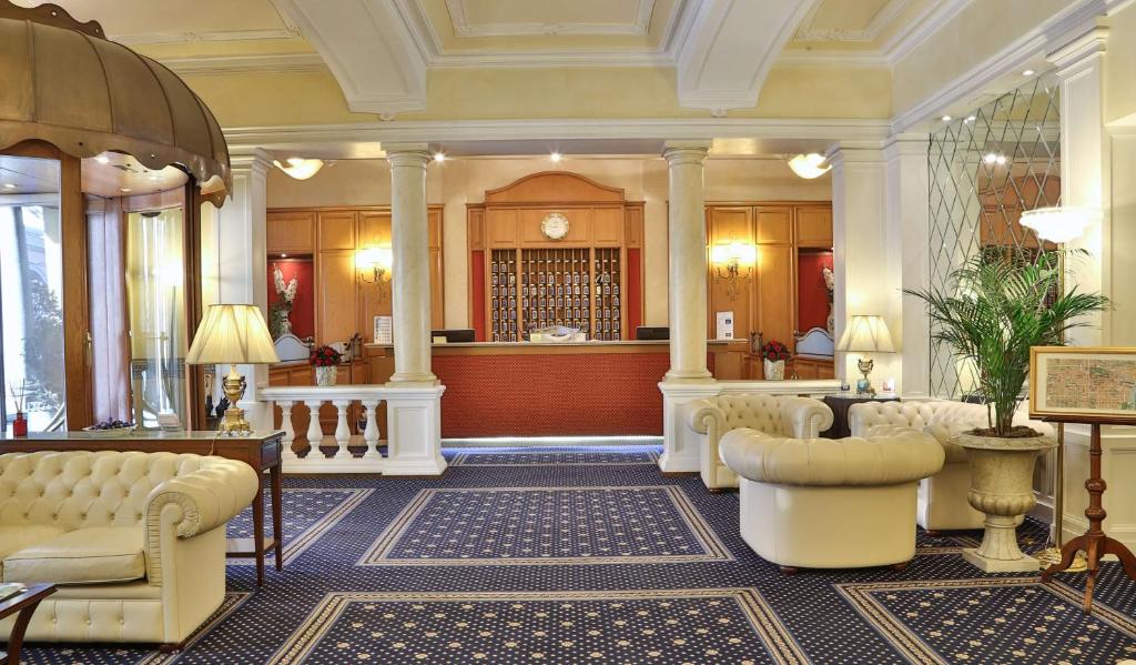 Best Western Plus Hotel Genova في تورينو: لوبي مع منطقة انتظار مع كنب وكراسي