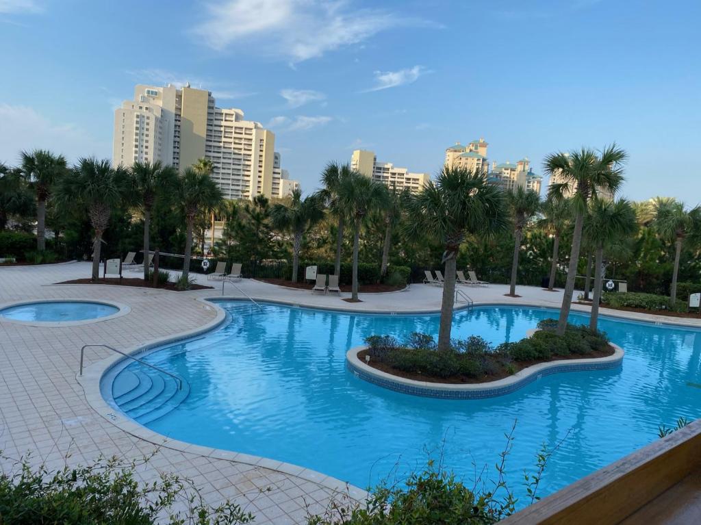 a pool with palm trees and buildings in the background at Ocean View Luxurious Condo-BEST location + balcony in Destin
