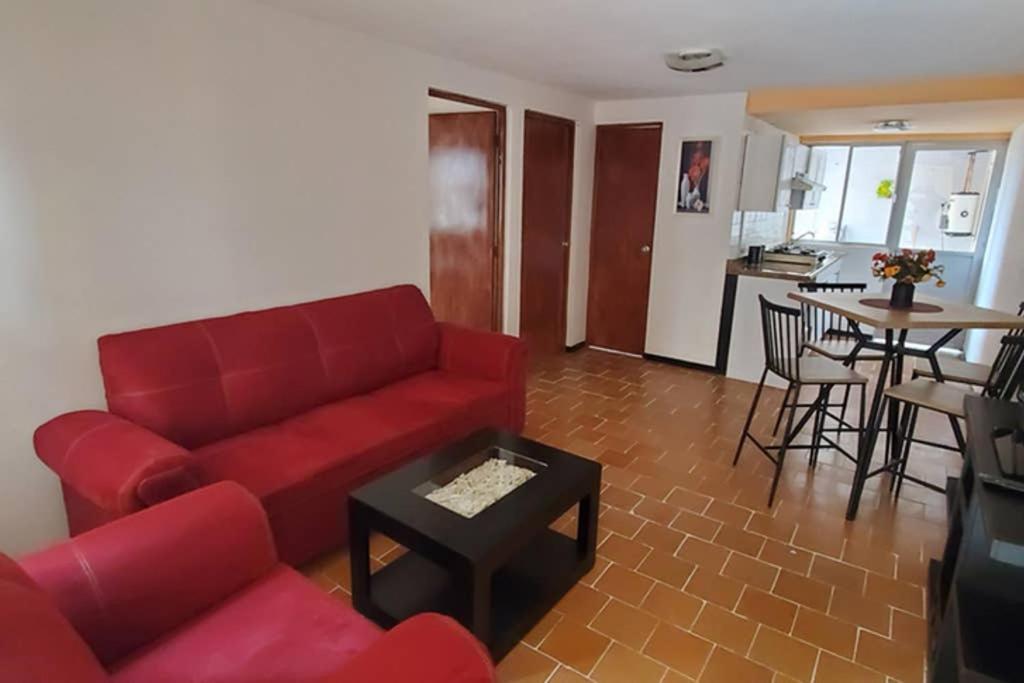 a living room with a red couch and a table at El corazón de Celaya in Celaya