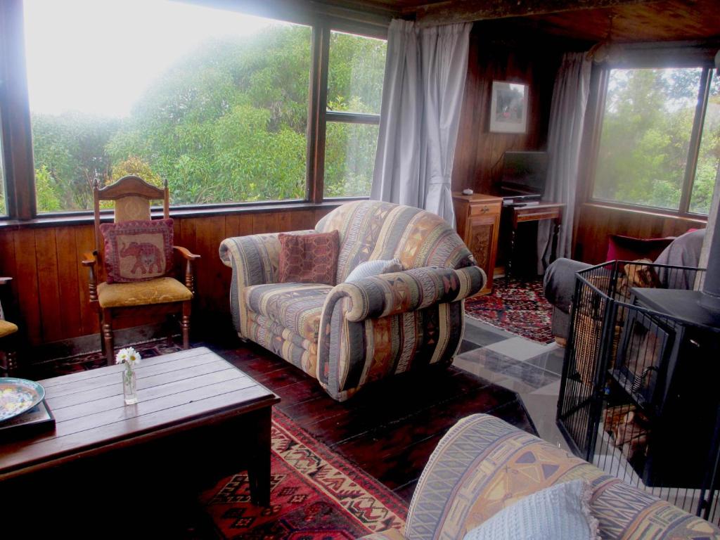 a living room with a couch and a chair at Catlins Lake Sanctuary in Owaka