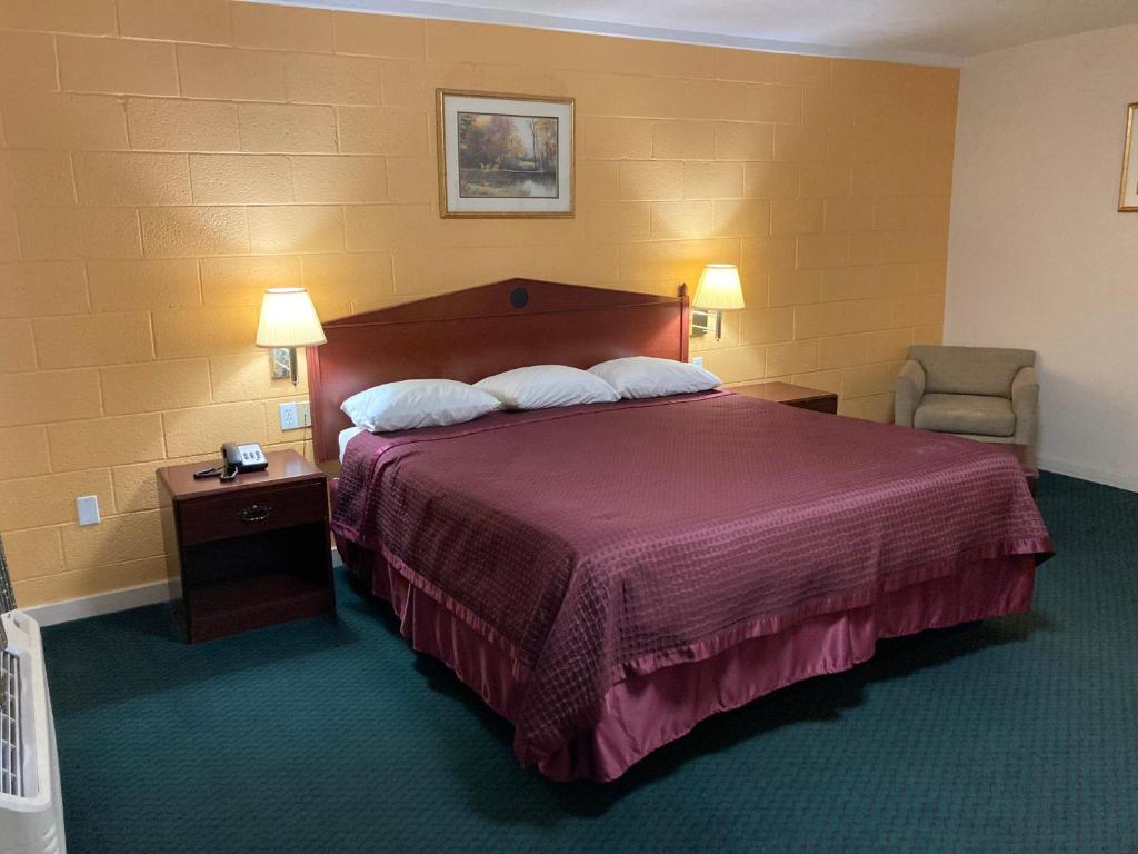 une chambre d'hôtel avec un lit et une chaise dans l'établissement Childress Inn, à Childress