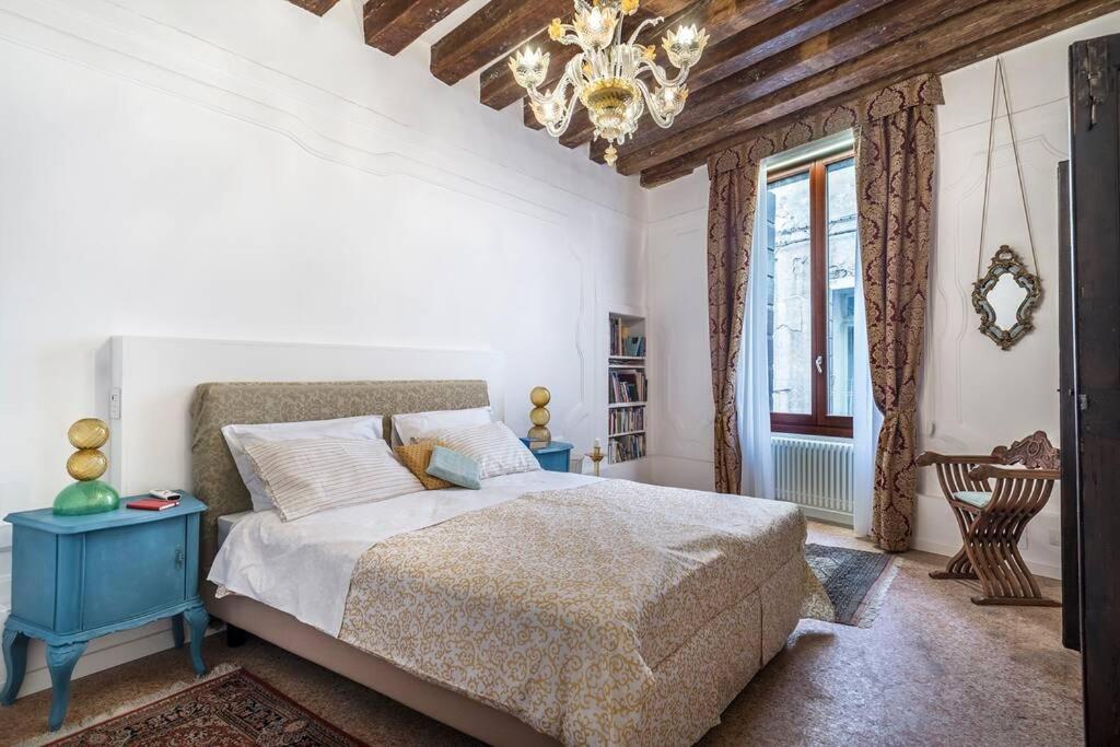 a bedroom with a bed and a chandelier at Appartamento Cassiano Rialto in Venice