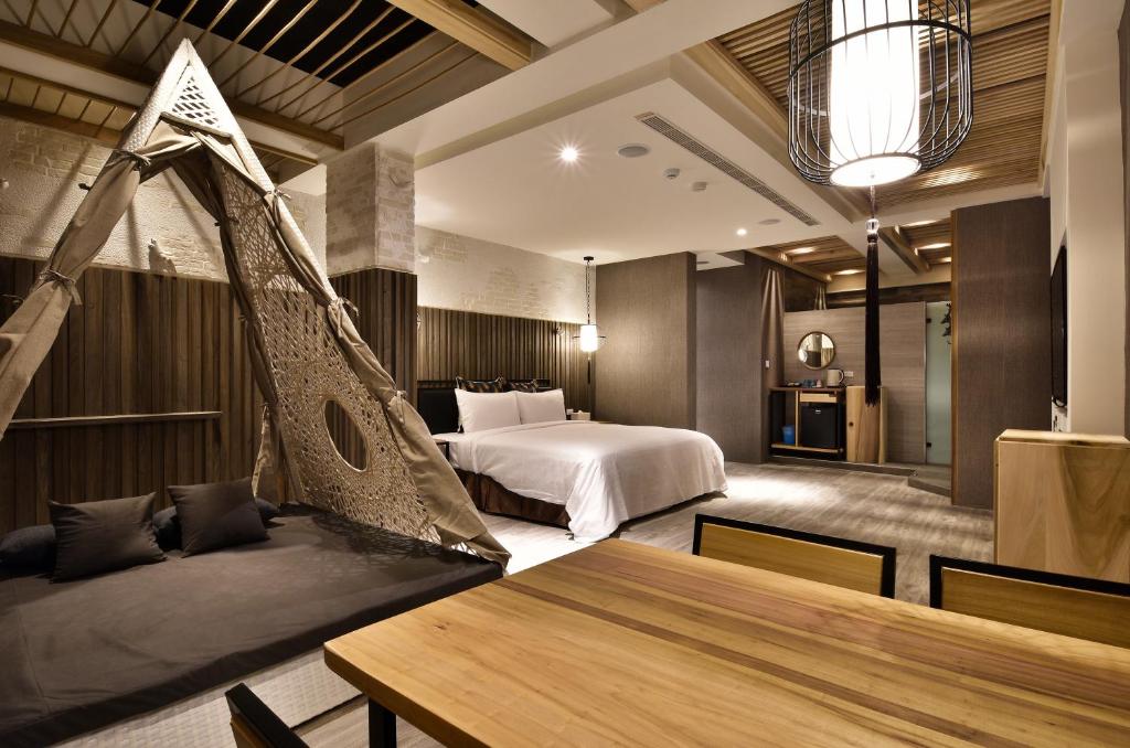 a hotel room with a bed and a hammock at 歐閣精品汽車旅館-簡愛館 in Kaohsiung