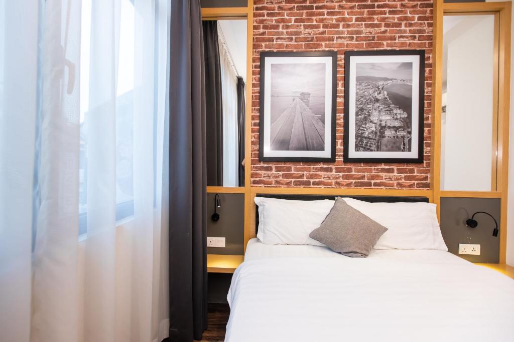 a bedroom with a large bed and a large window at B Street Hotel in George Town